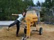 	Taia dancing with the small concrete mixer we rented to do the perimeter foundation.
